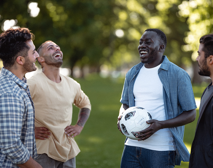 Young men playing soccer and talking about mental health
