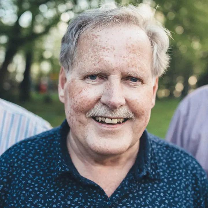 Senior gentleman smiling to camera.