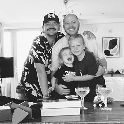 Black and white photo of a family with two children, smiling to camera.