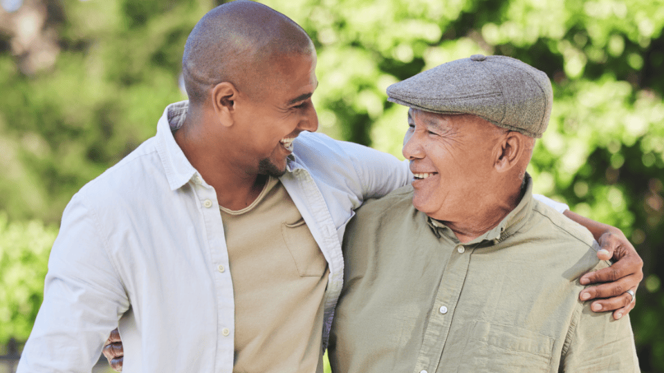 Photo of a father and son smiling with their arm around each other