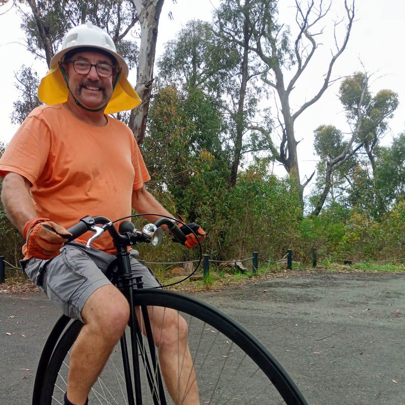 Photo of a man riding a penny farthing.