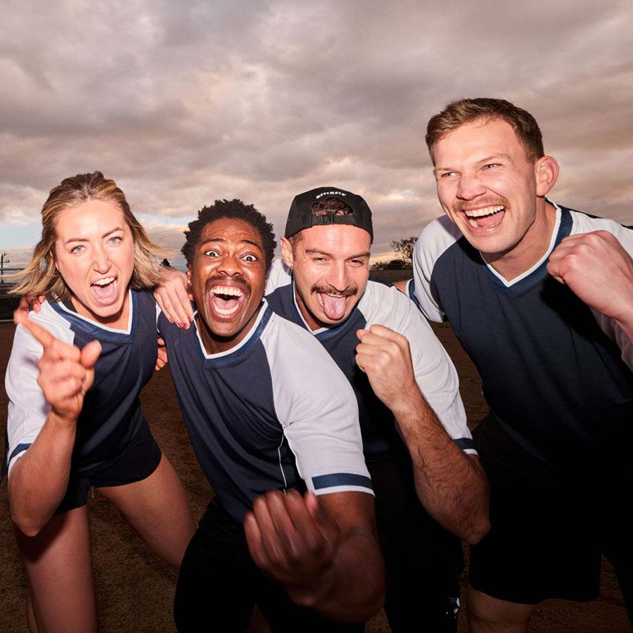 Photo of a sports team cheering to camera.